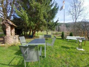 einen Tisch und Stühle im Gras mit einer Bank in der Unterkunft Holiday home in Saint Quirin with garden in Saint-Quirin
