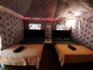 a bedroom with two beds in a room with wallpaper at Nature's Wood in Matheran