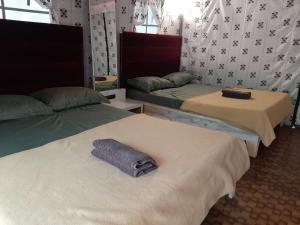 a room with two beds with towels on them at Nature's Wood in Matheran +34 photos