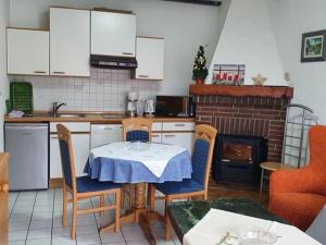 Rodemann的住宿－Lovely apartment with cosy terrace，厨房配有桌椅和壁炉。