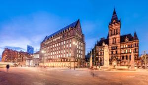 a large building with a clock tower in a city at Manchester Serviced Accommodation NorthernNightzzz - The Park in Manchester