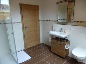 a bathroom with a toilet and a sink and a shower at Holiday apartment Burkart in Großweil