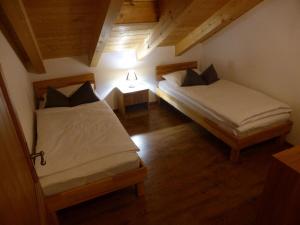 two beds in a small room with wooden floors at Holiday apartment Burkart in Großweil