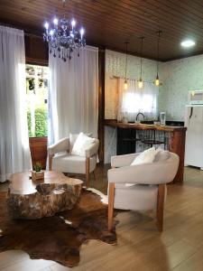 佩德拉阿祖爾的住宿－Recanto do Pimenta，客厅配有两把椅子和一张茶几