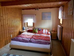 グロースシェーナウにあるRenate's holiday apartmentの木製の壁の部屋にあるベッドのある寝室