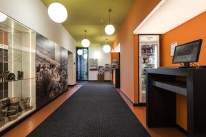 a hallway of a store with orange walls and a black carpet at Hotel Grenzfall in Berlin