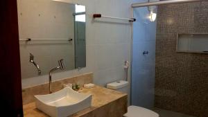 a bathroom with a sink and a toilet and a shower at Pousada Área Talismã in São Miguel do Gostoso