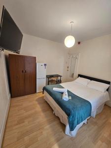 a bedroom with a large bed and a television at Bruce Rooms in London