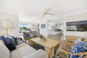 a living room with a couch and a table at Magnificent 4-Bed Waterfront With Pool & Views in Gold Coast