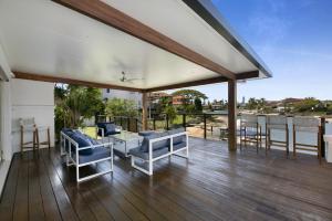 a porch with blue chairs and a view of the ocean at Magnificent 4-Bed Waterfront With Pool & Views in Gold Coast