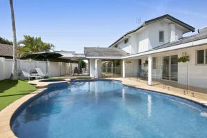 uma piscina em frente a uma casa em Magnificent 4-Bed Waterfront With Pool & Views em Gold Coast