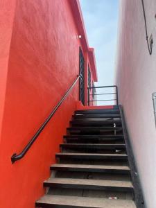 a stairway leading up to a red wall at Casa de chapis in Ensenada