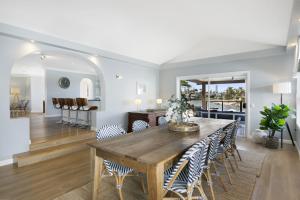 uma sala de jantar com uma mesa de madeira e cadeiras em Magnificent 4-Bed Waterfront With Pool & Views em Gold Coast
