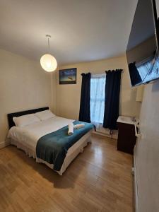 a bedroom with a bed and a flat screen tv at Bruce Rooms in London