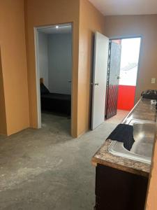 a kitchen with a sink and a living room at Casa de chapis in Ensenada