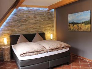 een slaapkamer met een bed voor een bakstenen muur bij Holiday maisonette apartment "Keilberg" in Annaberg-Buchholz