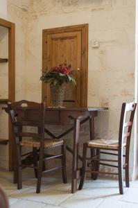 a table with a vase of flowers and two chairs at Lapignagialla in Martina Franca