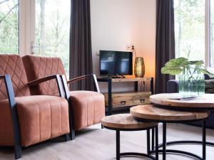 a living room with a couch and two tables and a tv at Charming apartment in Graach an der Mosel in Zorgvlied