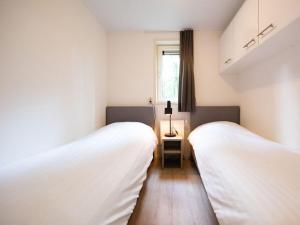 two beds in a small room with a window at Charming apartment in Graach an der Mosel in Zorgvlied