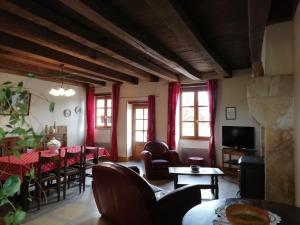 a living room with red curtains and a table and chairs at Gîte rénové au calme avec grand terrain, idéal télétravail, proche forêt et karting - FR-1-586-27 in La Celette