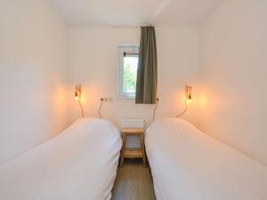 twee bedden in een kamer met een raam bij Pavilion 6 people with storage space in Zorgvlied