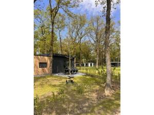 een uitzicht op de achtertuin van een hut in het bos bij Pavilion 6 people with storage space in Zorgvlied