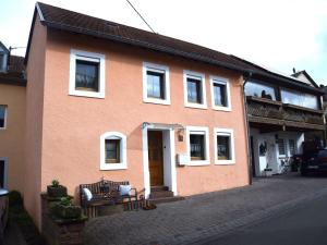 een oranje huis met witte ramen en een deur bij Holiday home in Wilsecker with private terrace 