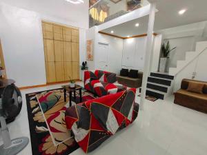 una sala de estar con 2 sofás y una alfombra en Private 2-Floors Bedroom near DVO Airport, en Davao City