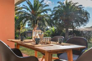 a wooden table in a room with palm trees at Villetta Norsi in Capoliveri