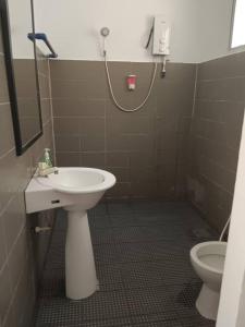 La salle de bains est pourvue d'un lavabo et de toilettes. dans l'établissement Pom-Pom Celebes Beach Resort邦邦岛西里伯斯度假村, à Semporna