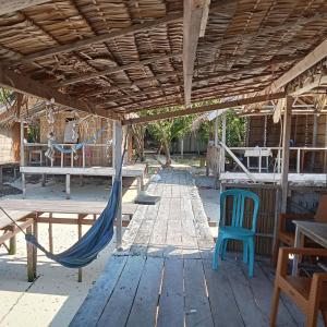 a hammock on a porch with a table and chairs at byuk Beya homestay in Kri