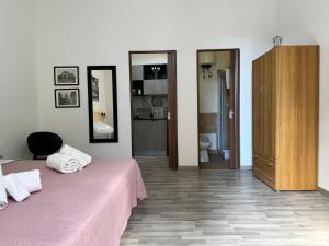 een slaapkamer met een roze bed en een badkamer bij Marilù in Palermo