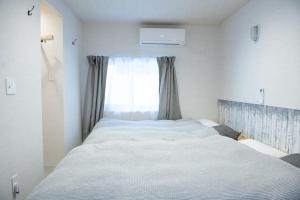 - un grand lit dans une chambre avec fenêtre dans l'établissement Sauna Villa Yoichi / 4 bed room with private sauna, à Kurokawamachi