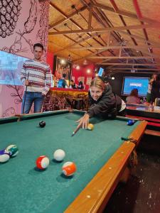 a woman is playing pool in a pool table at Pariwana Hostel Cusco in Cusco