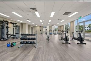 a gym with a lot of treadmills and machines at Serain Apartment on Northbourne Ave Canberra in Canberra