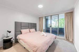 En eller flere senger på et rom på Serain Apartment on Northbourne Ave Canberra