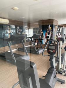 einem Fitnessraum mit mehreren Laufbändern und einem Simulator in der Unterkunft Flat Mobiliado em excelente localização in Campina Grande