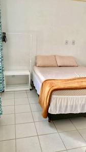 um quarto com uma cama e piso em azulejo em Apt inteiro bem localizado com Wi-Fi e aceita Pets em Aracaju