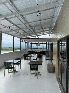 a dining room with tables and chairs and windows at Flat Mobiliado em excelente localização in Campina Grande