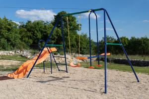 an empty playground with an orange slide and swings at Family friendly house with a swimming pool Veliki Brocanac, Zagora - 22666 in Klis