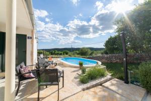 a patio with a pool and a table and chairs at Family friendly house with a swimming pool Veliki Brocanac, Zagora - 22666 in Klis