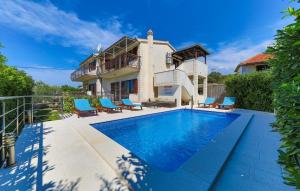 une villa avec une piscine en face d'une maison dans l'établissement Family friendly house with a swimming pool Vrsine, Trogir - 22668, à Marina