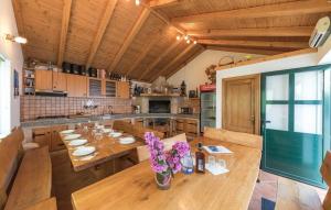 une cuisine avec une table en bois et des fleurs violettes. dans l'établissement Family friendly house with a swimming pool Vrsine, Trogir - 22668, à Marina