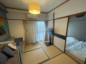 a small room with a bed and a mirror at 高原マンション 205 in Horinouchichō