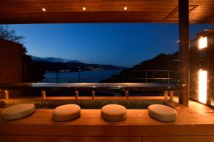 a row of stools sitting on a bench in front of a window at Uminohana in Atami