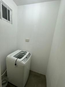 uma pequena casa de banho branca com WC num quarto em Arezzo Davao GZJ condotelle 300mbps wifi em Davao