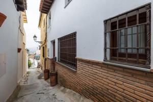 an alley with a brick wall and a window at Relajante casa en el centro in Granada
