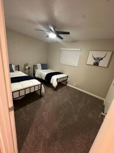 a bedroom with two beds and a ceiling fan at Modern Oasis near North Phoenix in Phoenix