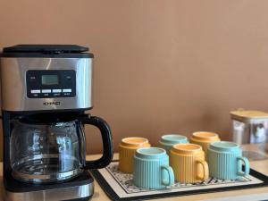 a coffee maker sitting on a counter next to cups at Swing & Pillows - KL Kuchai Lama formerly known as Sunrise Inn in Kuala Lumpur