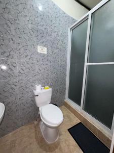 a bathroom with a white toilet and a sink at Casa Maya Itza in Flores